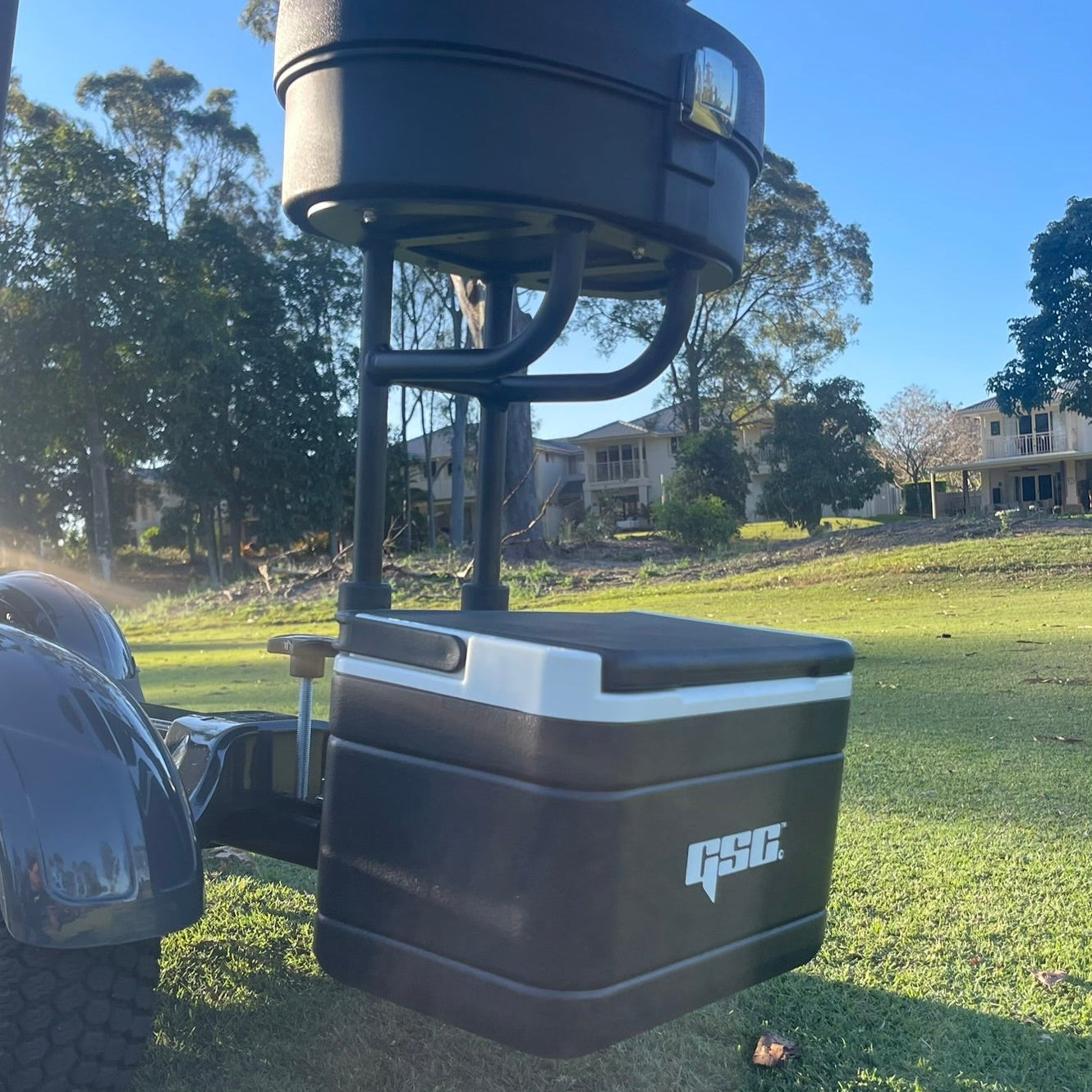 Black GSC Tourer X Seat Mounted cooler Closed with a handle on a grassy area
