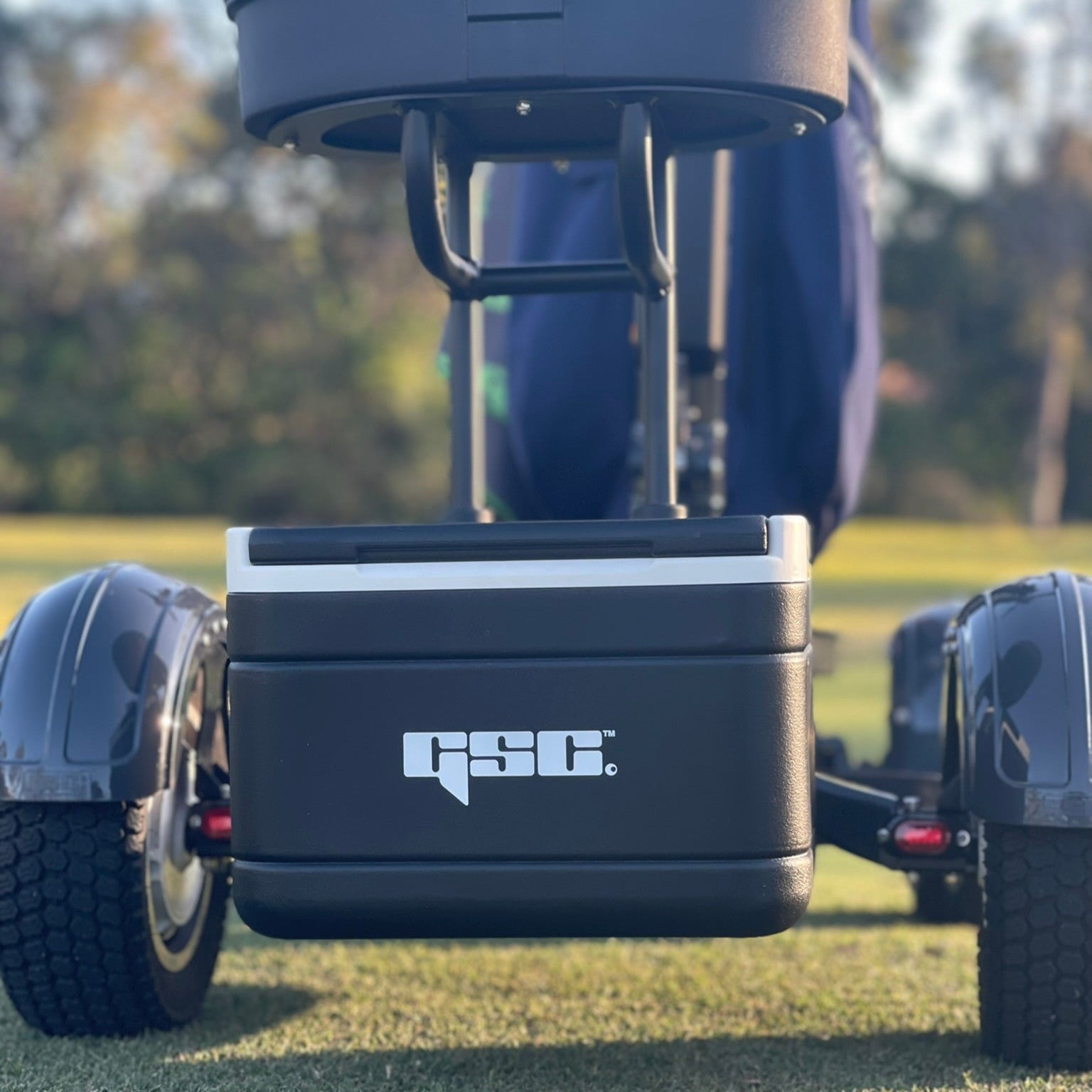 GSC cooler attached to a golf cart on a grassy field