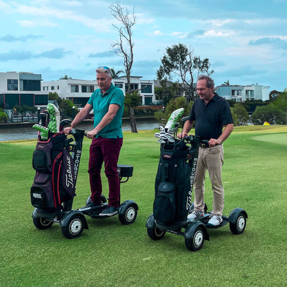 Two men with golf carts on a golf course with a scenic background